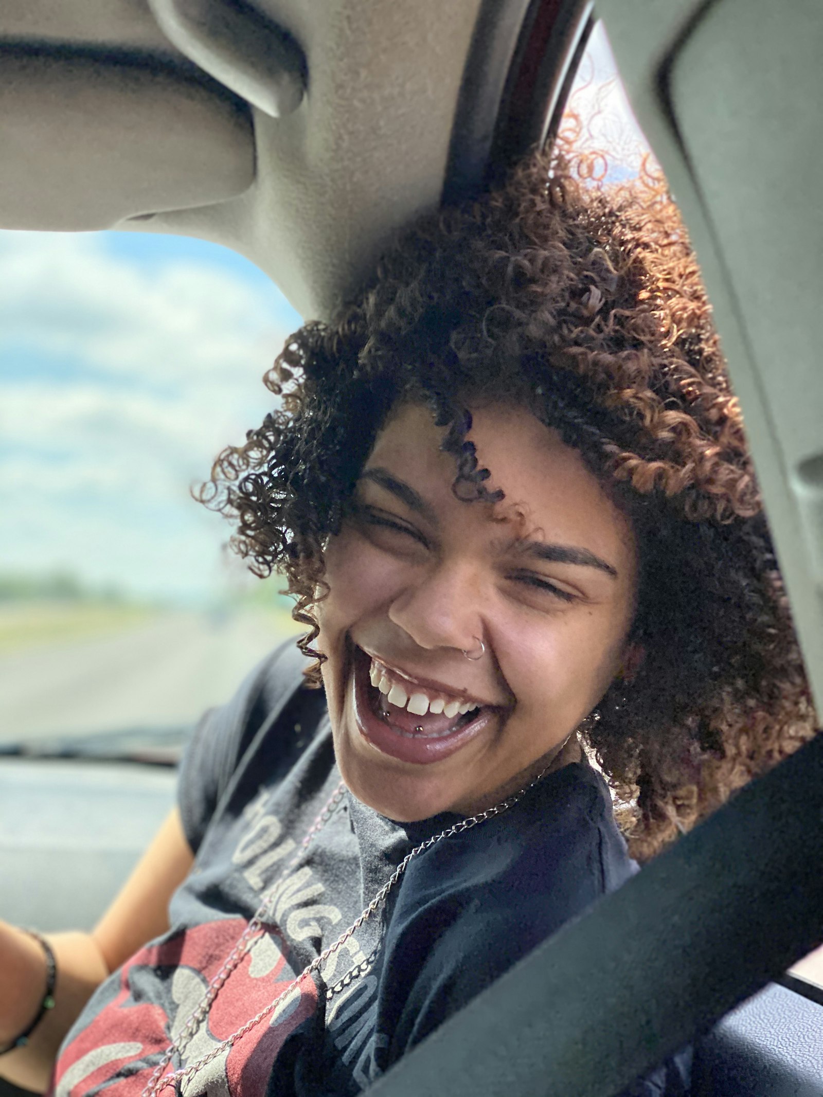 A learner laughing in her car