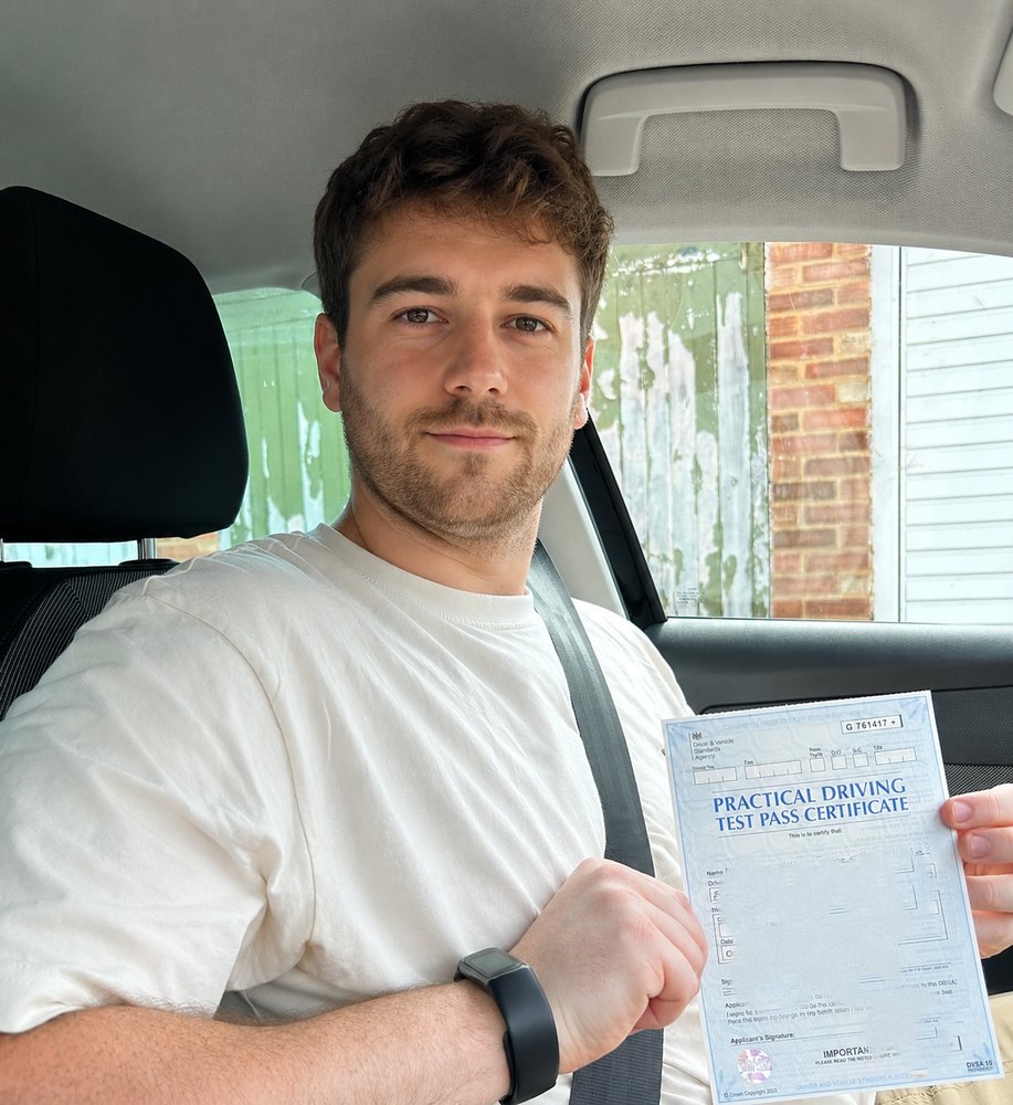Bradley holding his pass certificate after passing his UK driving test