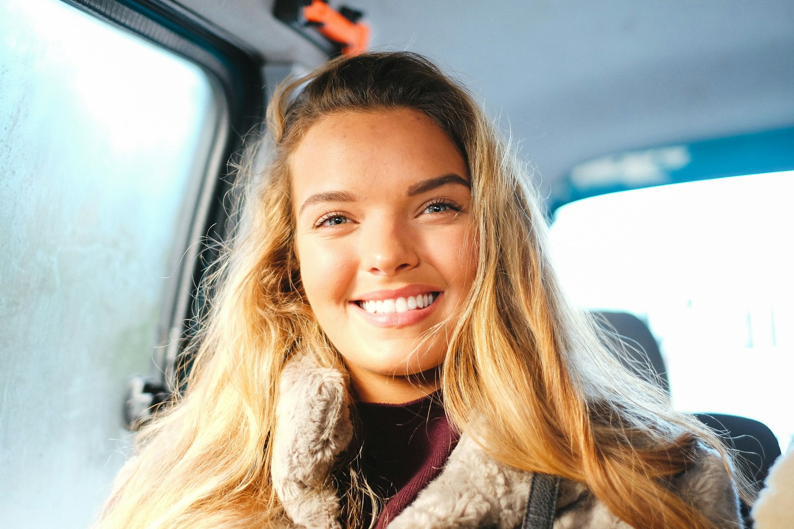 A young driver smiling in her car