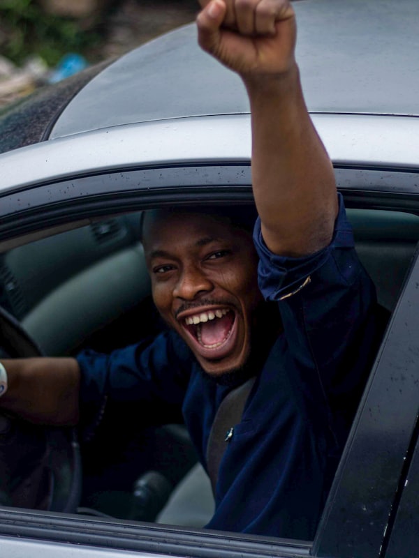 A driver celebrating with his fist out of the car window